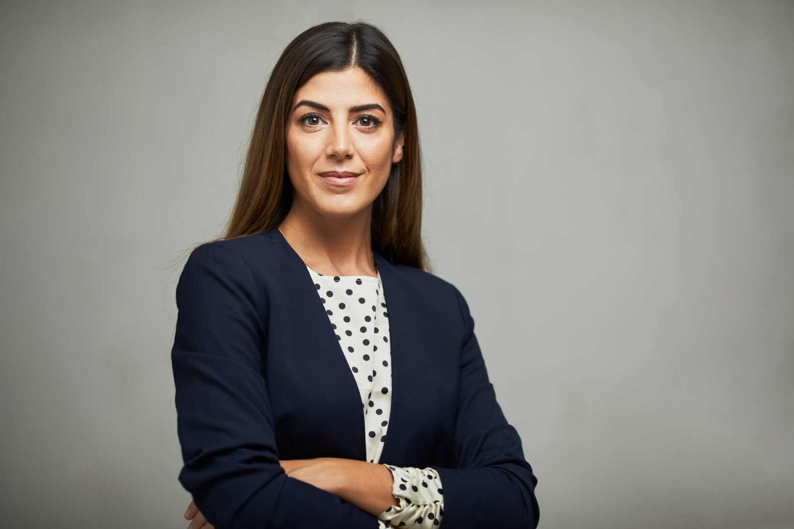 Woman in business attire with confident expression.