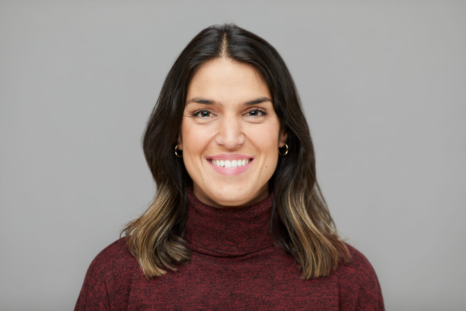 Smiling woman in a maroon sweater.