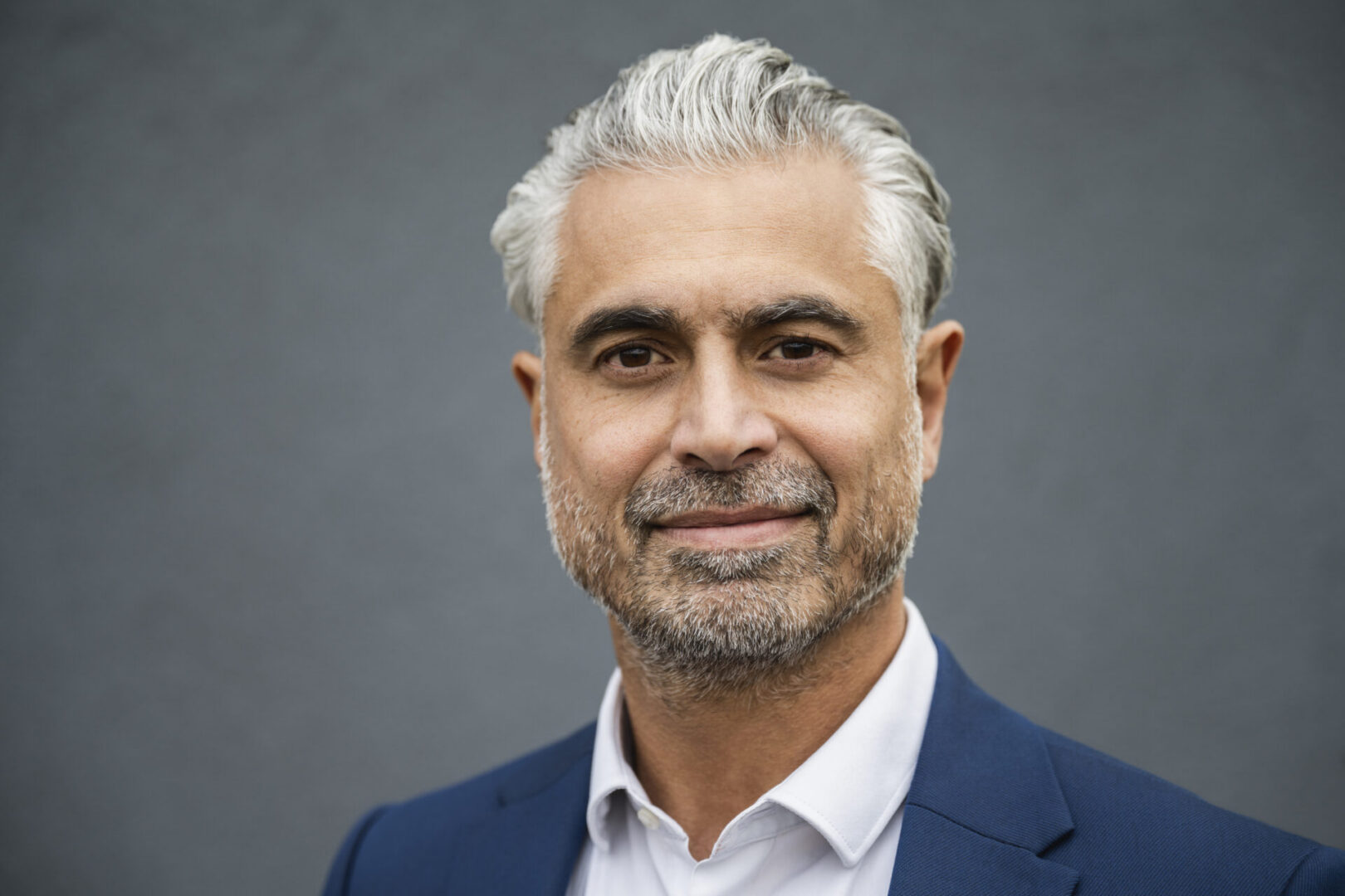 Smiling man with gray hair and beard.