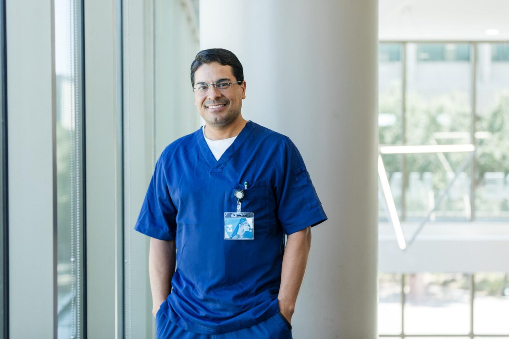 Healthcare worker smiling near windows