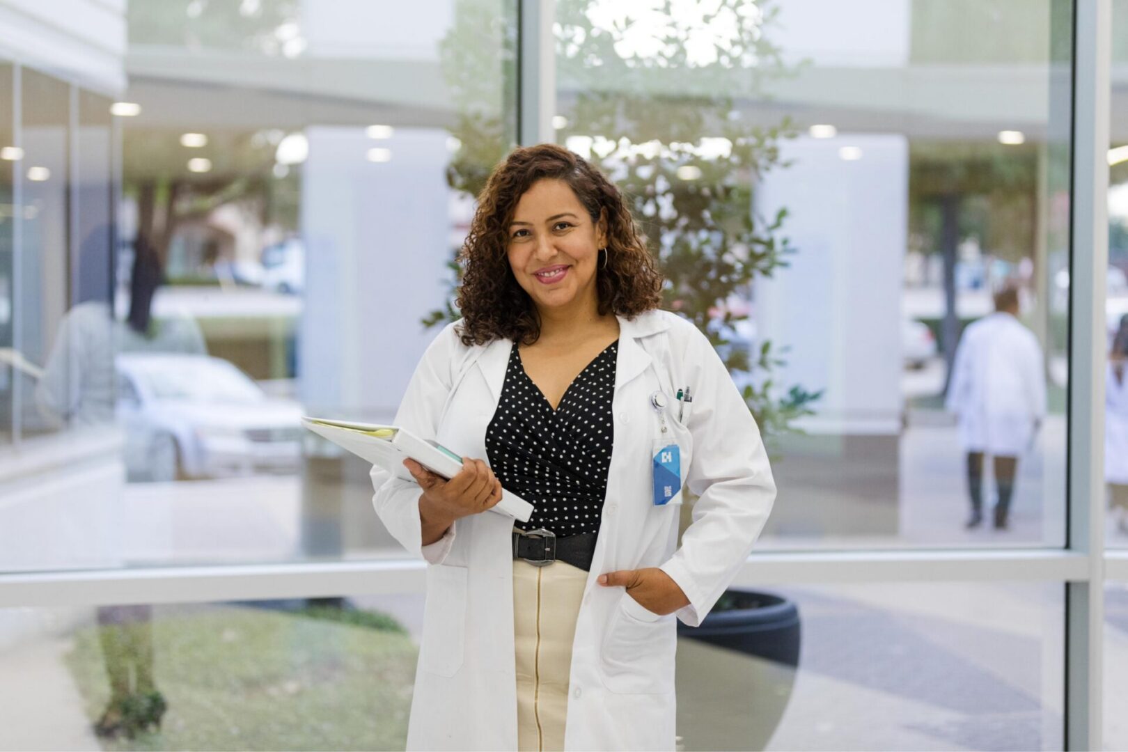 Doctor smiling and holding a medical file.