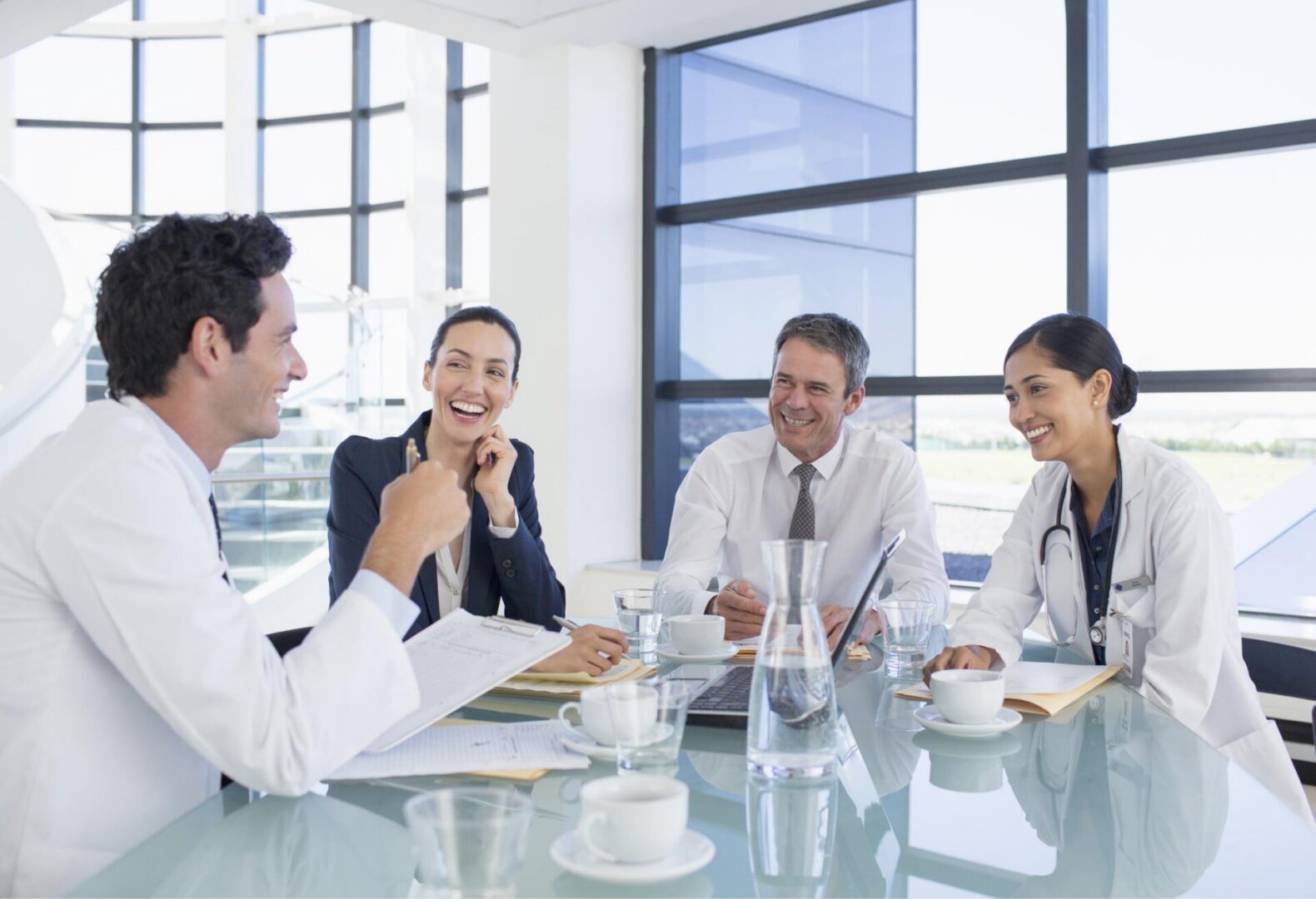 Doctors in meeting, discussing and smiling.
